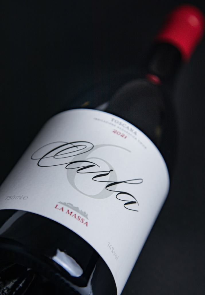 Wine bottle tilted diagonally with a white label reading La Massa, Toscana 2021, red capsule.