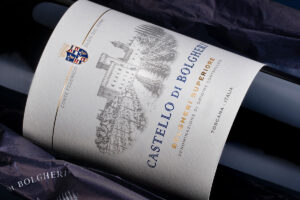 Castello di Bolgheri Bolgheri Superiore wine bottle label with crest and castle illustration in blue and gold accents.